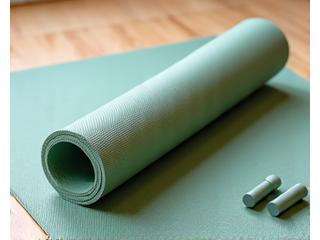 Rolled yoga mat with a water bottle and small weights.